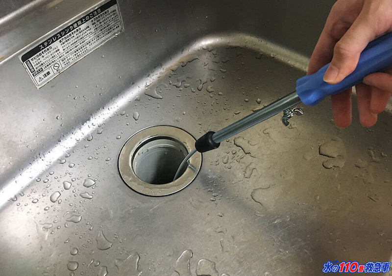 排水溝に入れたワイヤーをまわす
